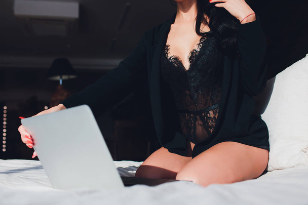Beautiful, young girl posing in front of a web camera, working as a sexual model. The concept of online flirting, sex on the Internet. - Fotó, kép