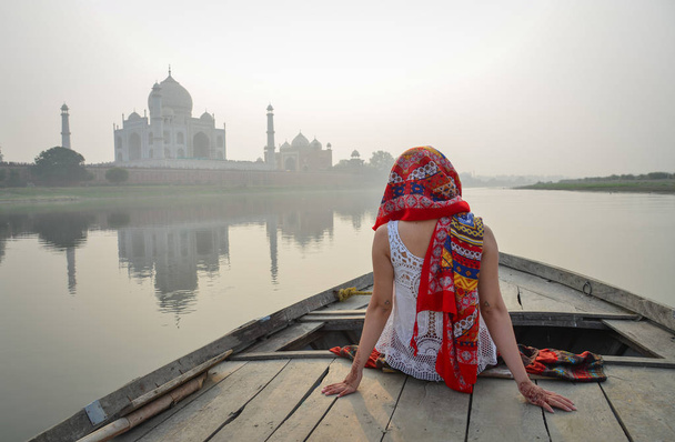 eine Frau beobachtet den Sonnenuntergang über dem Taj Mahal - Foto, Bild