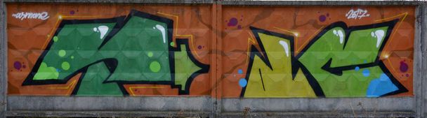 Θραύσμα από χρωματιστούς πίνακες γκράφιτι του δρόμου με καμπύλες και σκίαση. Φόντο της κουλτούρας της σύγχρονης τέχνης της νεολαίας. Πράσινα κίτρινα χρώματα - Φωτογραφία, εικόνα