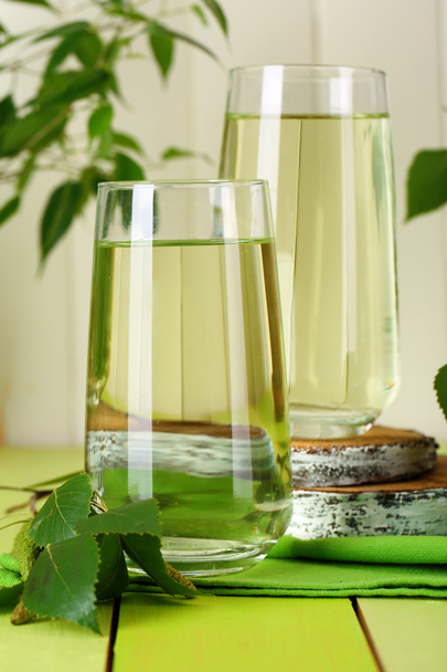Glasses of birch sap on green wooden table - Zdjęcie, obraz