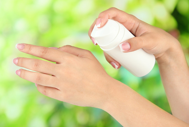 Woman applying cream on hands on bright background - Foto, immagini