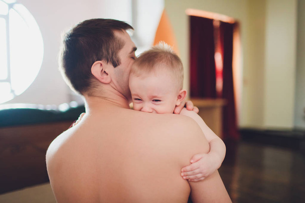 Small baby with his father. Father holds baby in his hands. - Foto, imagen