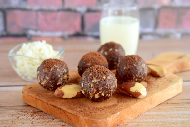 Healthy organic brazil nut coconut chocolate energy balls served with milk - Fotoğraf, Görsel