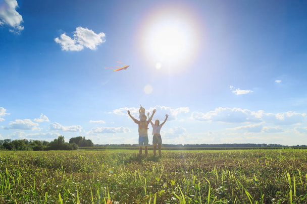 母と父と娘は野原で凧を飛ばしている。フロン - 写真・画像