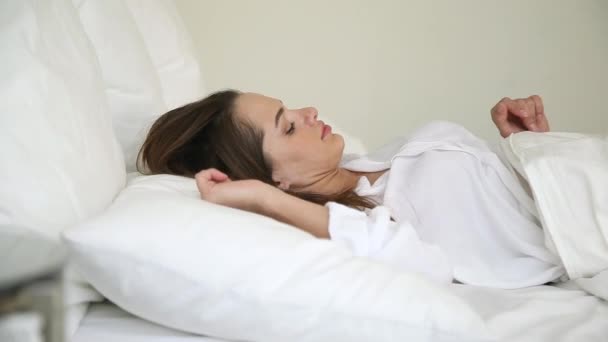 Sick woman waking up in bed touching back feeling pain - Filmmaterial, Video