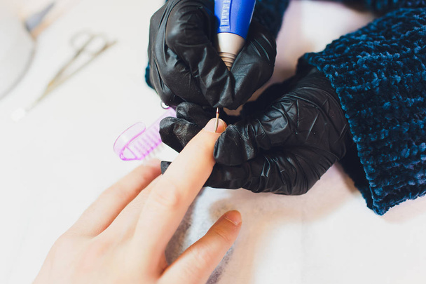 Hands in gloves cares about mans hand nails. Manicure beauty salon. - Valokuva, kuva