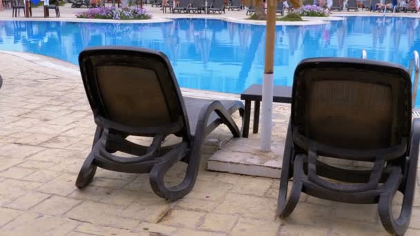 Sunbed Lounger cerca de la piscina con agua azul en el Resort de Egipto. - Metraje, vídeo