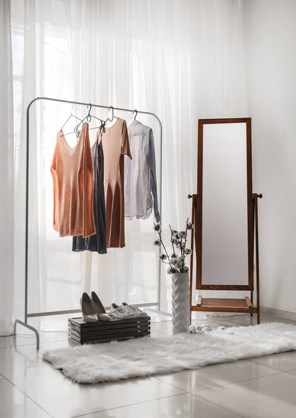 Big mirror with female clothes in interior of room - Φωτογραφία, εικόνα