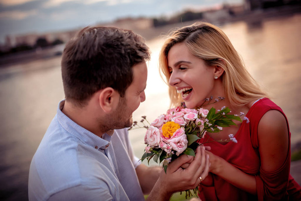 Mladý muž dává krásnou kytici květin na svou přítelkyni. - Fotografie, Obrázek