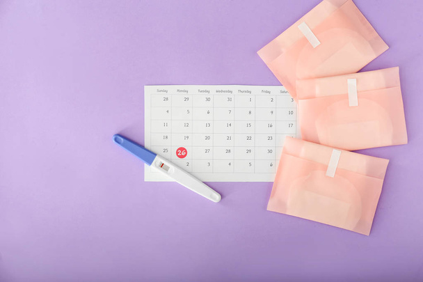 Negativní těhotenský test, kalendář a menstruální podložky na barevném pozadí - Fotografie, Obrázek