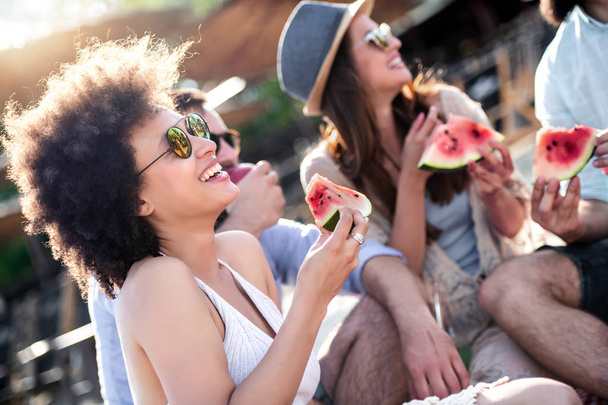 Happy mladí přátelé jíst meloun na pláži. - Fotografie, Obrázek