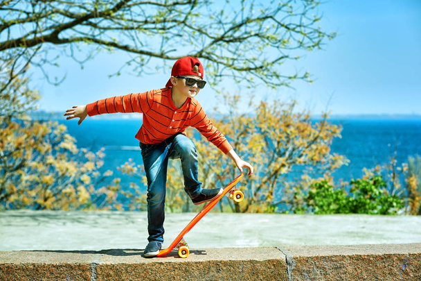 kluka na skateboard v parku. dítě se naučí jezdit na tabuli - Fotografie, Obrázek