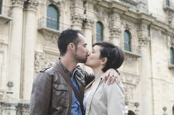 Couple kiss near to european cathedral in closeup frame image. - Photo, Image