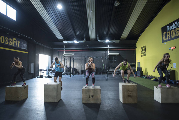 People training in crossfit class jumping on boxes - 写真・画像