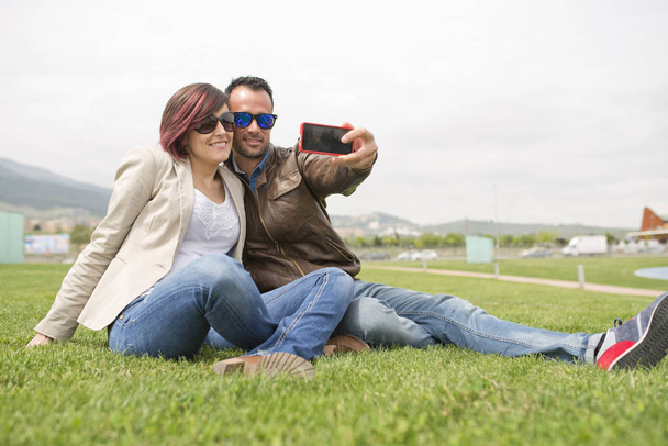 Young sunglasses couple at city park  - 写真・画像