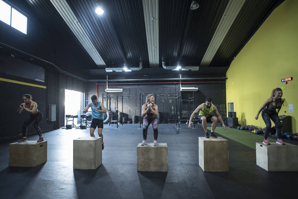 People training in gym jumpin on boxes - Foto, Imagem