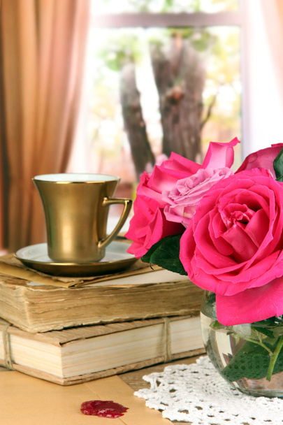 Beautiful pink roses in vase on wooden table on window background - Fotó, kép