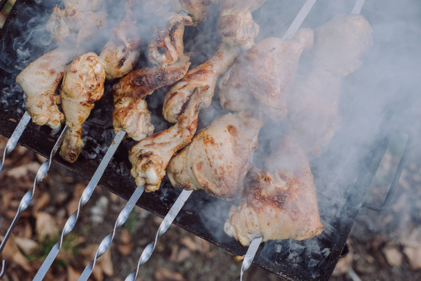 Подготовка барбекю гриль с куриным мясом на открытом воздухе в летнее время. Приготовление пищи в природе
 - Фото, изображение