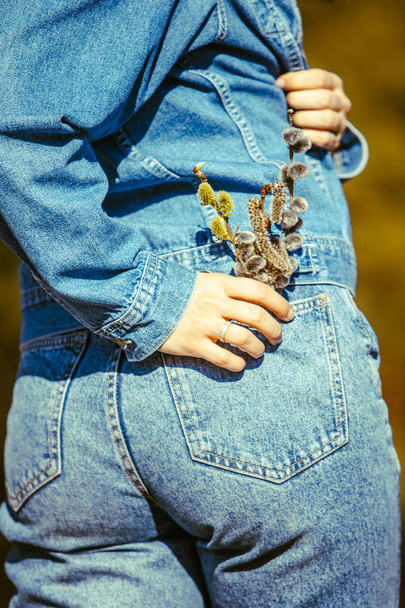 Женская задница в джинсах, цветущая цветы в кармане
 - Фото, изображение
