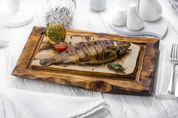 Spicy grilled fish with tomato on a board - 写真・画像