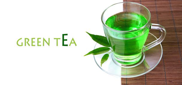 Taza transparente de té verde en estera de bambú, aislada en blanco
 - Foto, Imagen