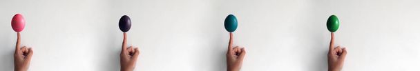 FInger holding a Painted Easter Boiled Egg isolated on a White Wall, collage - Foto, Bild