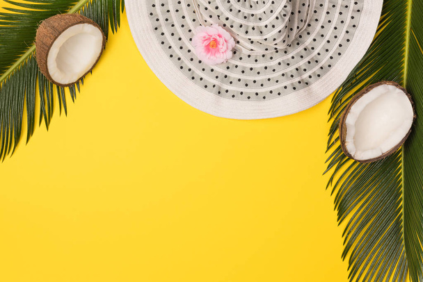 hat, coconuts and palm leaves isolated on yellow background, top view - Фото, зображення