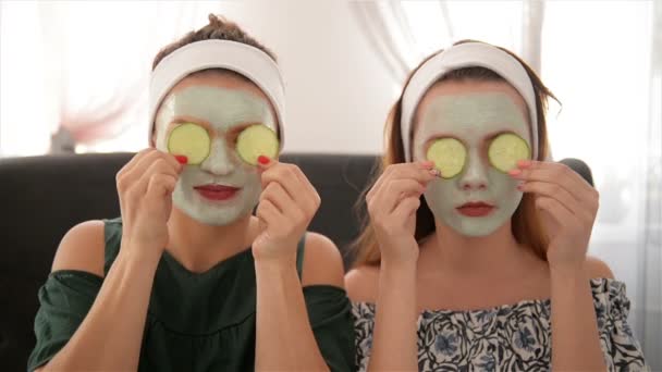 Two Smiling Women Holding Cucumbers. Portrait of Girls in Spa Salon. Health Beauty Concept, Face Mask, Together. - Filmati, video