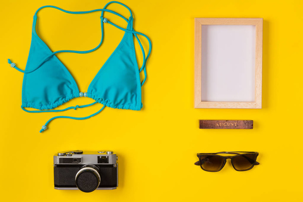 swimsuit, frame, camera, sunglasses on a yellow background, top view - Photo, image