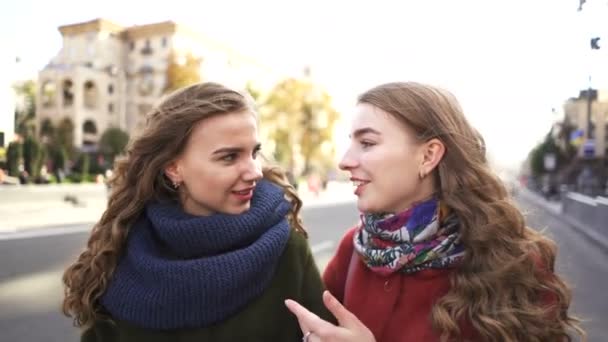   4k. Young pretty women sister twins walk in city street with smile and laugh.  Steady shot - Footage, Video
