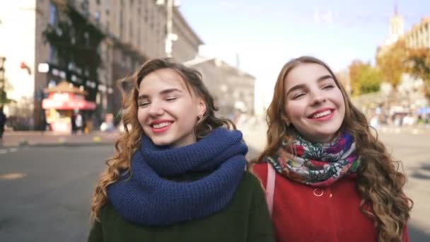   4k. fiatal nők nővére ikrek modellek séta a városi utcán mosolyogva. Folyamatos Portrékép - Felvétel, videó