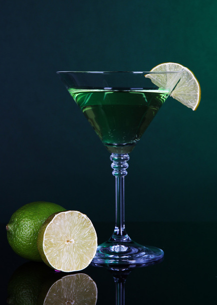 Green cocktail with lime on dark green background - Foto, Imagem