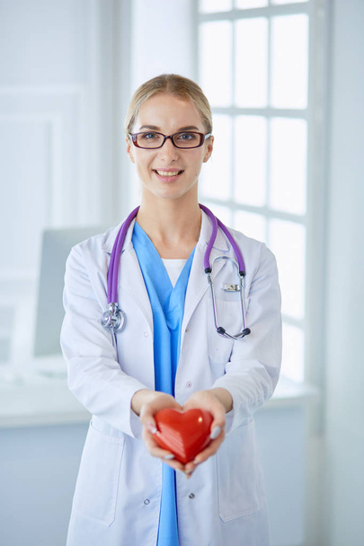 Doctor with stethoscope holding heart, isolated on white background - Foto, afbeelding