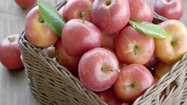 těsné záběry červených jablek v koši na dřevěném stole - Záběry, video