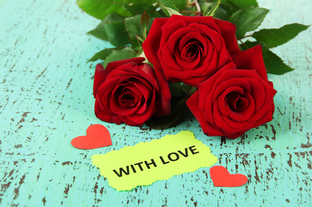 Beautiful roses, on color wooden background - Fotografie, Obrázek