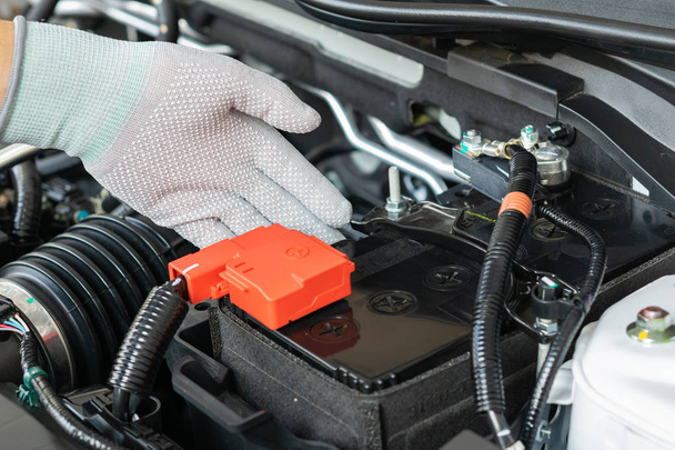Técnico comprobar la batería terminal del coche
 - Foto, imagen