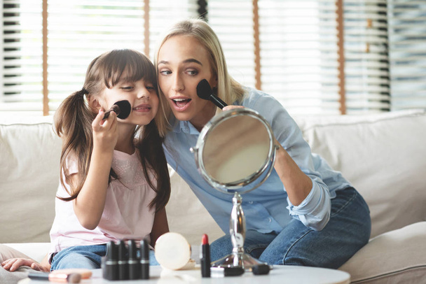 Mom and Daughter applying cosmetic with brushes. - Photo, image