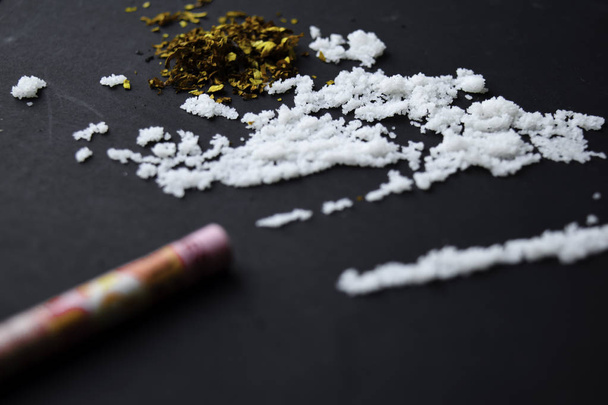 Spritze und Indonesien Rupiah bereit für den Einsatz auf dunklen Tisch. Selektiver Fokus auf Kokain - Foto, Bild