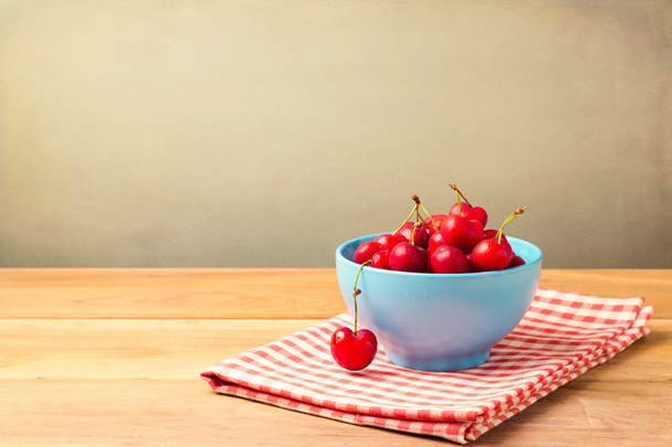 Bowl full of cherries on tablecloth - Photo, Image