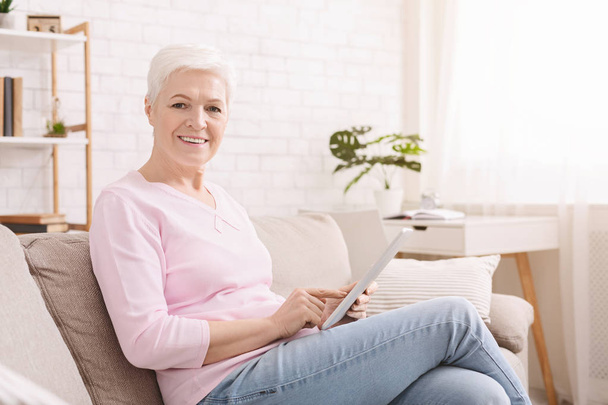 Allegro anziana donna godendo tablet digitale a casa
 - Foto, immagini