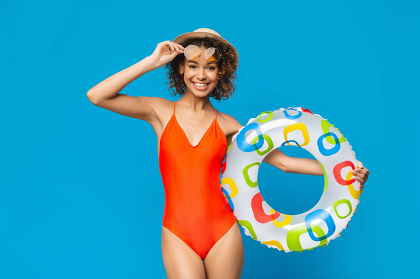 Élégante fille noire en maillot de bain et lunettes de soleil posant avec cercle gonflable
 - Photo, image