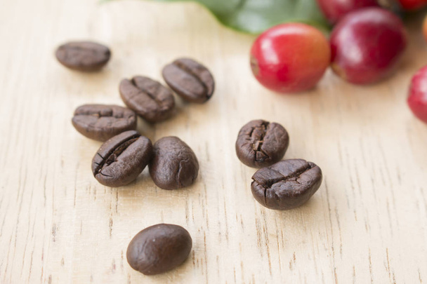 кавові ягоди та кавові зерна на дерев'яній панелі
 - Фото, зображення