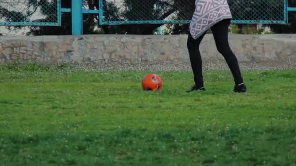 Una chica irreconocible patea la pelota en el estadio. Mujer joven
 - Metraje, vídeo