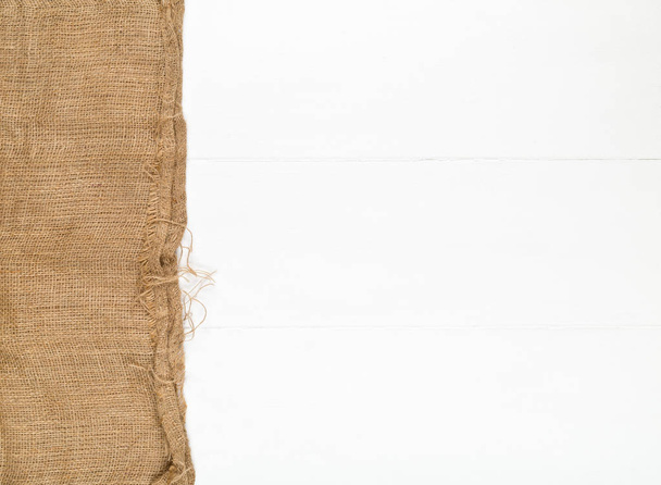 Burlap fabric cloth on white wooden kitchen table with copyspace - Φωτογραφία, εικόνα