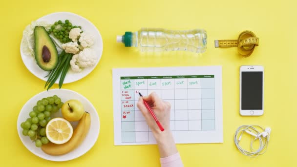 Mantener un calendario de acondicionamiento.concepto de alimentación saludable, dieta, vista superior, fondo amarillo
 - Metraje, vídeo