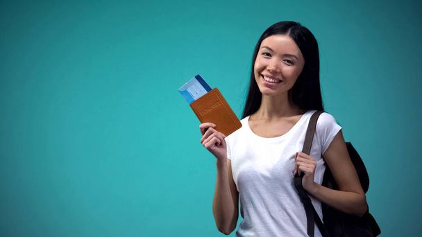 Χαμογελαστό γυναίκα με σακίδιο δείχνει διαβατήριο με εισιτήρια, εκδρομές, διακοπές - Φωτογραφία, εικόνα