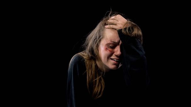 Hopeless female marital violence victim with wound on face crying sexual slavery - 写真・画像