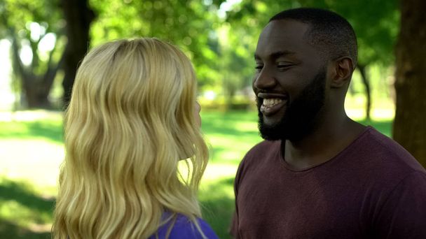 Smiling afro-american man looking at girlfriend, dating outdoors weekend in park - Fotoğraf, Görsel