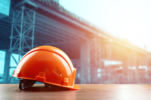 Orangeconstruction helmet close-up on the background of construction. The concept of architecture, construction, engineering, design. Copy space. - Foto, imagen