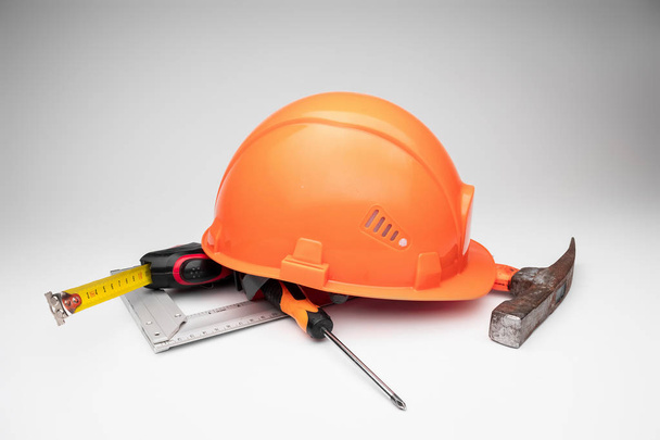 White construction helmet, tape measure, hammer, screwdriver on a light background. Concept architecture, construction, engineering, design, repair. Copy space. - Foto, Imagen